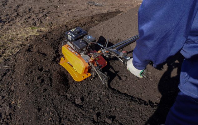 Placa vibratória realizando compactação de solo granular em obra de construção civil